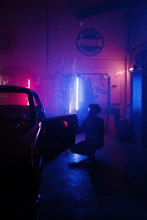 Man in Black Jacket Sitting on Black Car