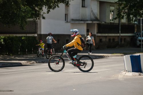 Free Side view of anonymous cyclist in protective helmet riding bike on asphalt roadway in town Stock Photo