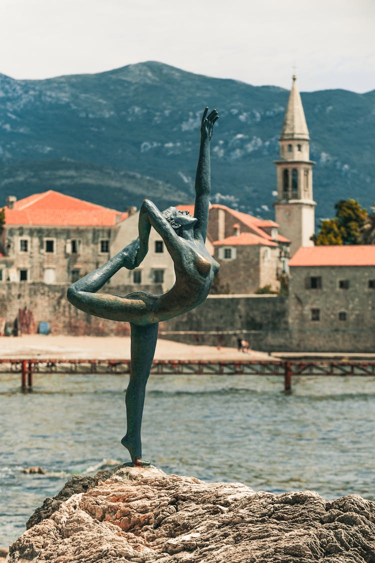 Statue Of Ballerina Near Sea And Old House Facades