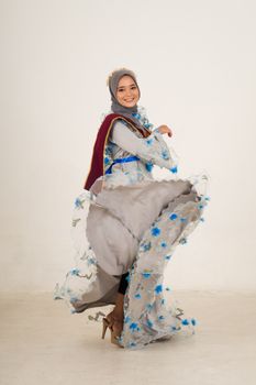 在充满活力的工作室里，一位身着传统服装的年轻女子快乐地旋转着