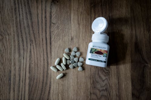 Stack of pills placed on wooden table