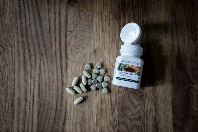 Stack Of Pills Placed On Wooden Table