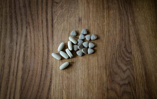 Free From above of set of different assorted medical pills arranged on lumber surface Stock Photo