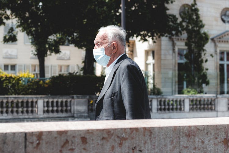 Old Man In Mask On City Street