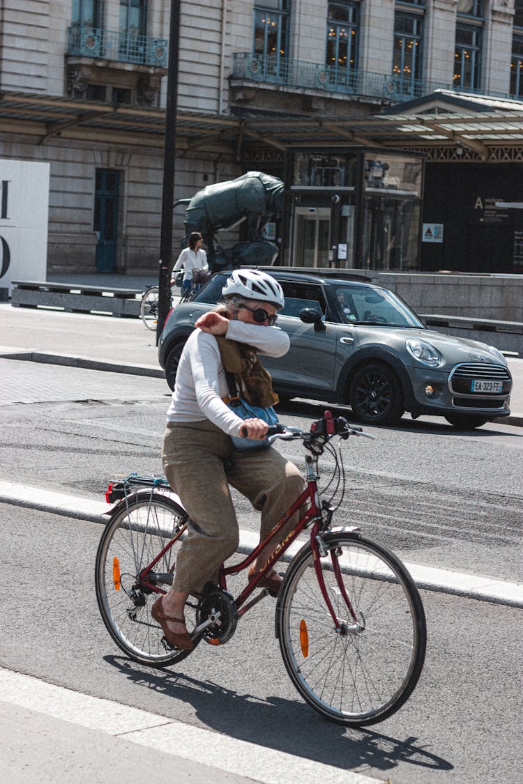 Anonymous Old Woman Riding Bicycle On City Street