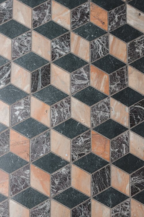 Top view abstract pattern of mosaic tiles of black beige and gray marble colors forming cube shapes on floor