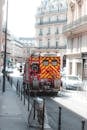 Fire engine truck driving along narrow busy street