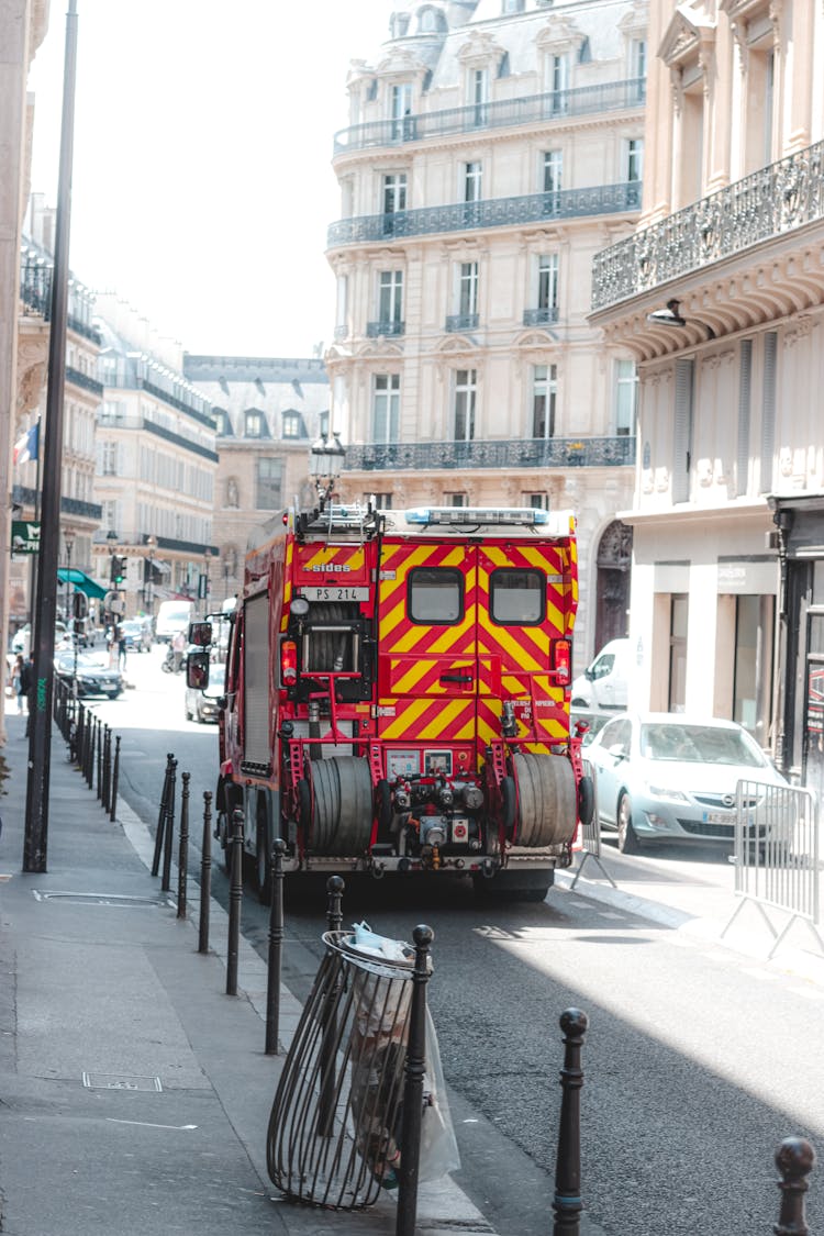 Fire Engine Truck Driving Along Narrow Busy Street