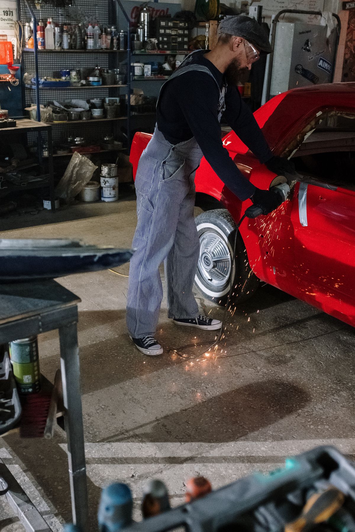 Mechanic grinding a car body in a garage