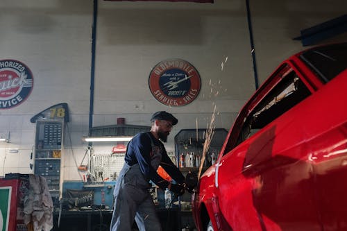 Man in Black Suit Standing Beside Red Car