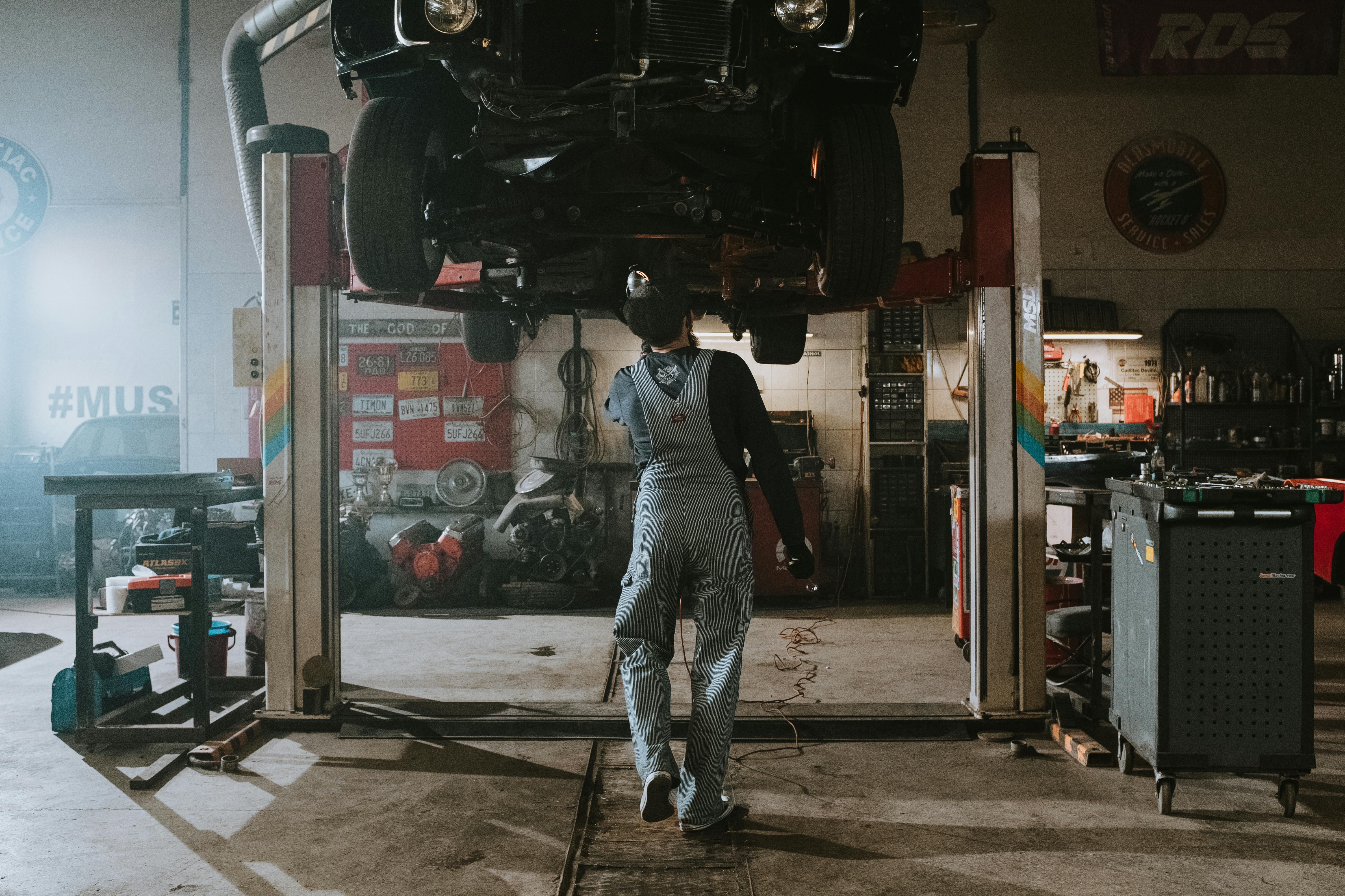 Man in Black T-shirt and Blue Denim Jeans Standing Near Black Car ...