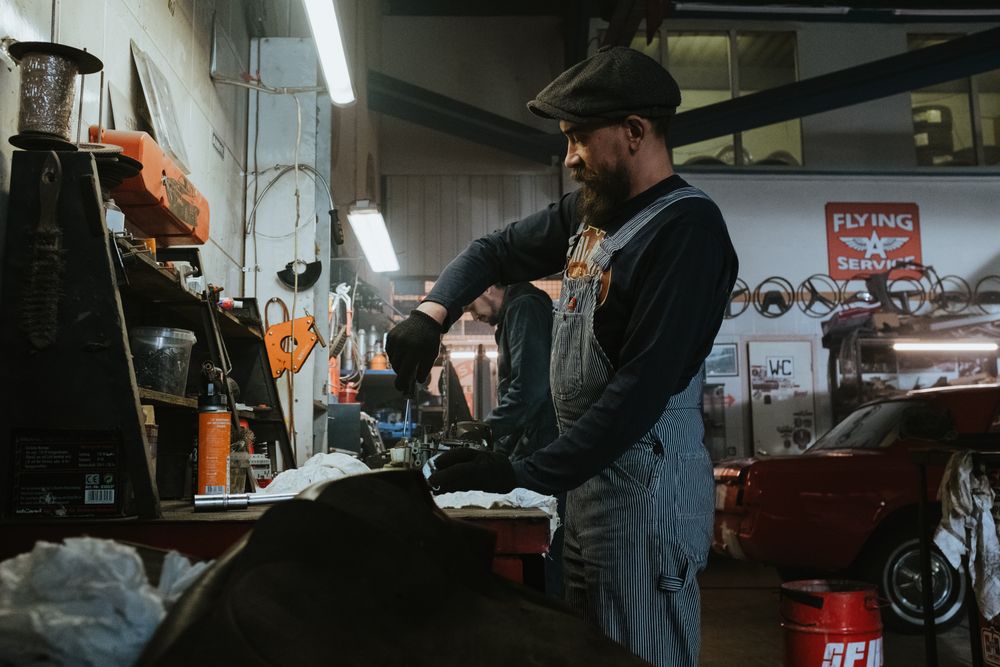 Petr Dvořák, automechanik, pracuje u pracovního stolu ve své dílně v Ostravě