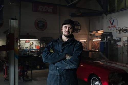 Man in Blue Zip Up Jacket Standing Near Red Car