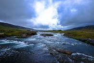在阴沉的天空下，河流蜿蜒穿过郁郁葱葱的迷人景致