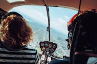 Anonymous tourists flying in helicopter on sunny day