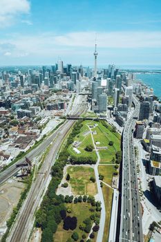 Breathtaking aerial view of modern architecture and green territories of Toronto city located on shore of lake on sunny day