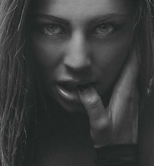 A Close-up Shot of a Woman Biting Her Fingernail