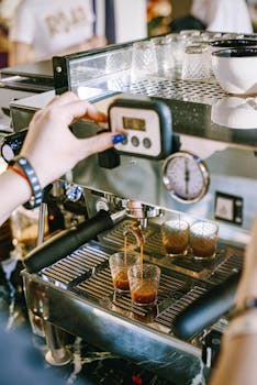 Close-up of a barista making espresso with a modern coffee machine in a café.