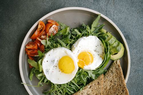 Free A delicious flat lay of a nutritious breakfast featuring eggs, avocado, and tomatoes. Stock Photo