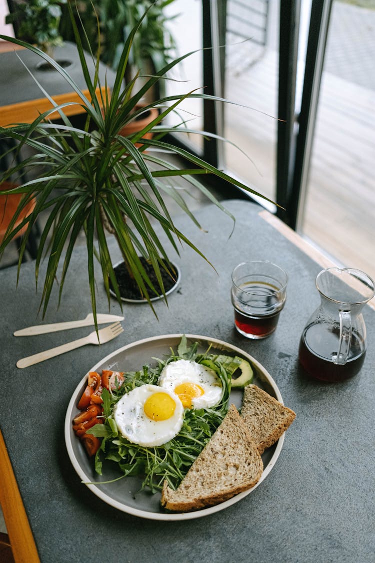 A Food On Ceramic Plate Near The Coffee On The Table