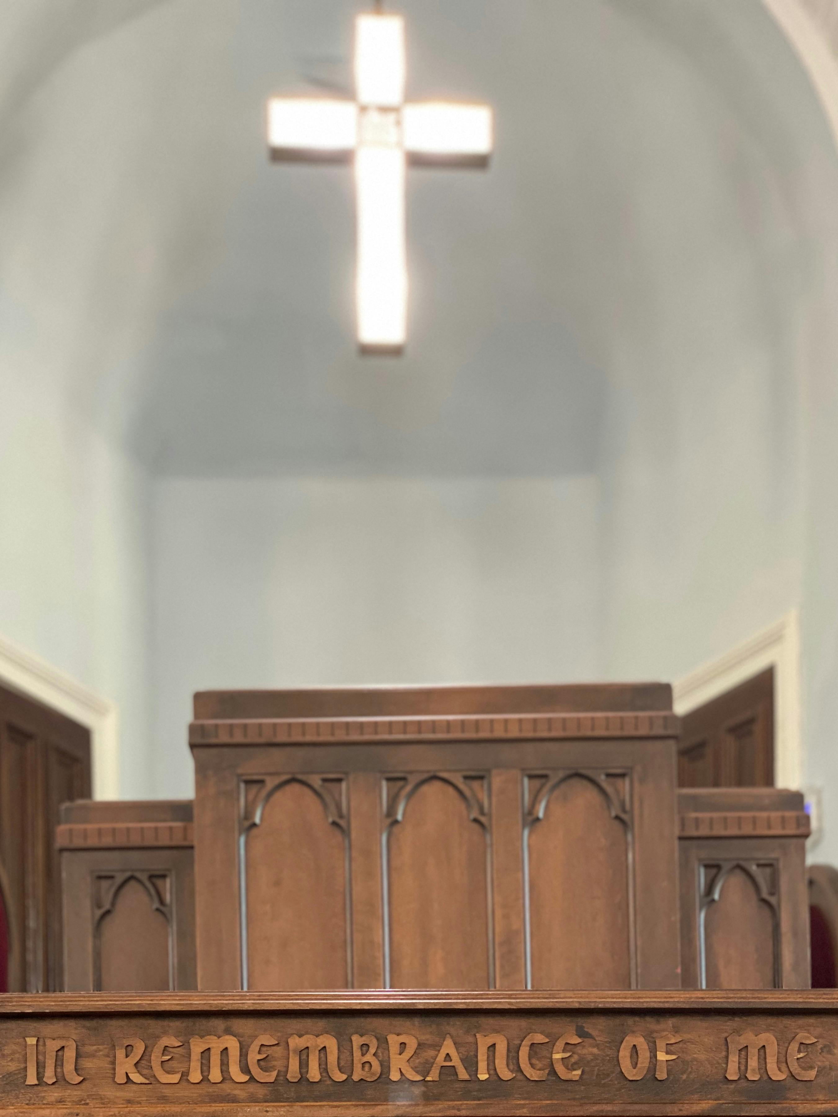 illuminated cross over wooden church altar