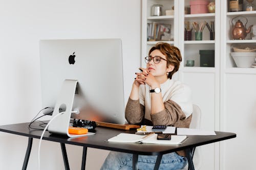 Free Focused female employee reading information on computer in office Stock Photo