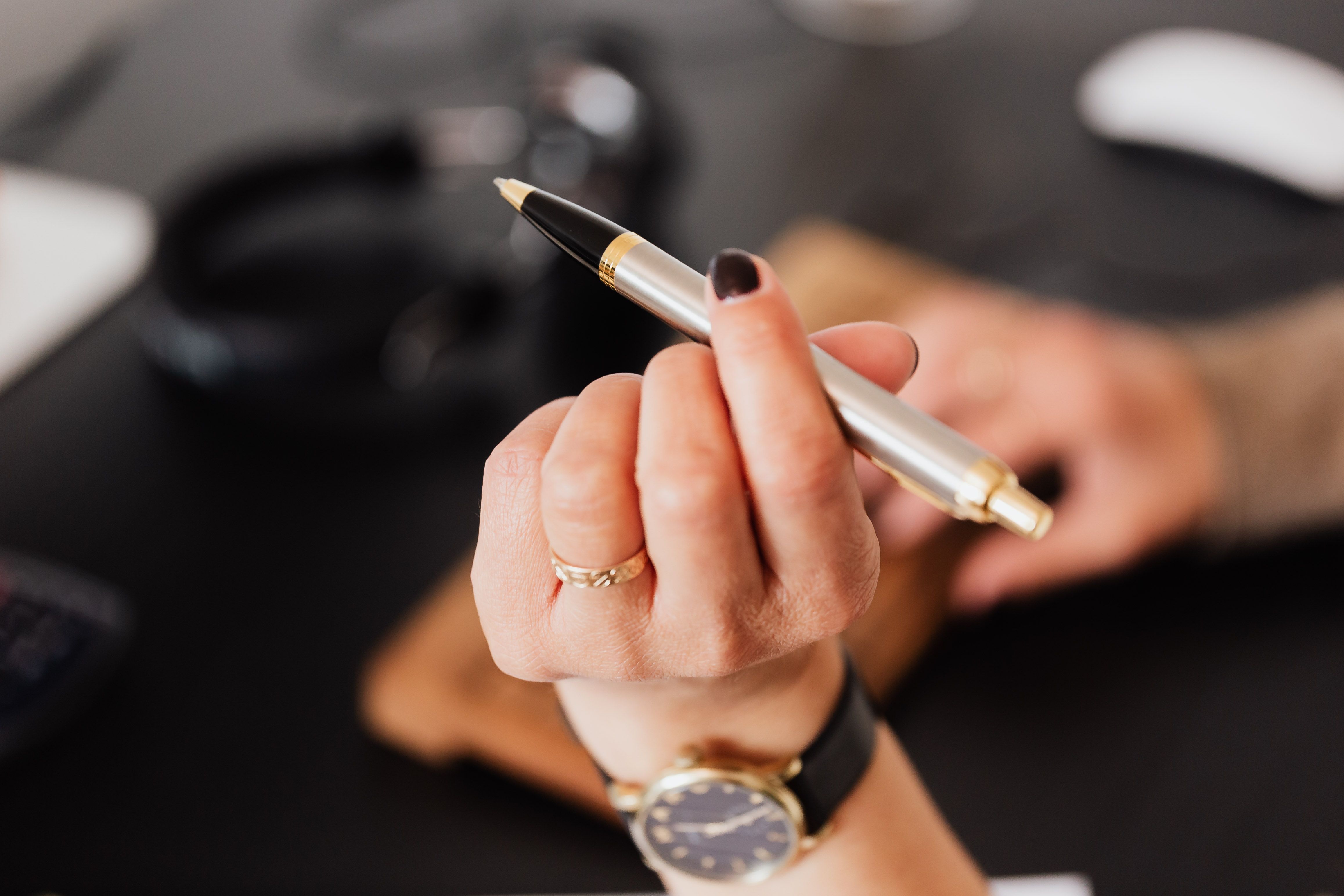 Hand holding a pen, representing the shift from manual drafts to an AI seo article writer.