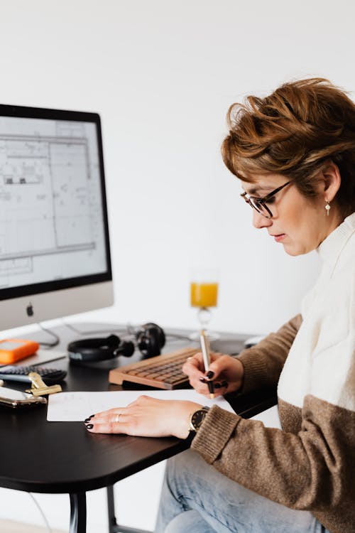 Serious adult lady doing paperwork in modern office