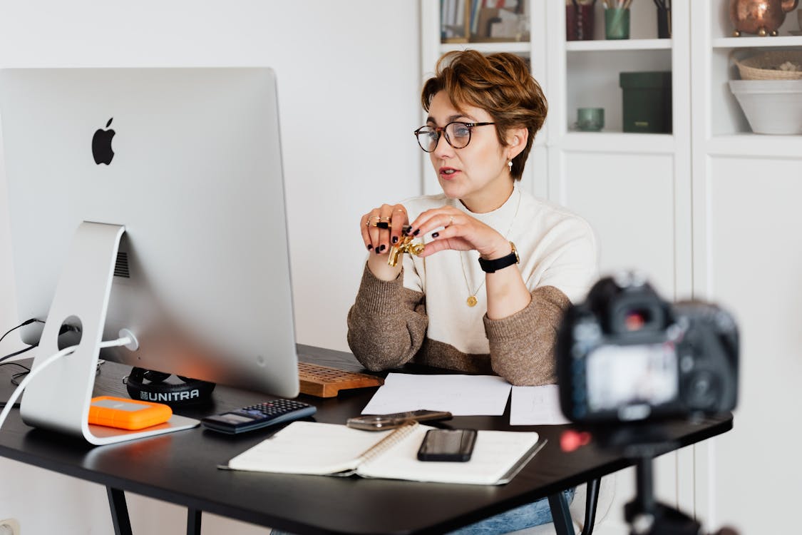 Free Confident elegant lady in eyeglasses hosting webinar Stock Photo