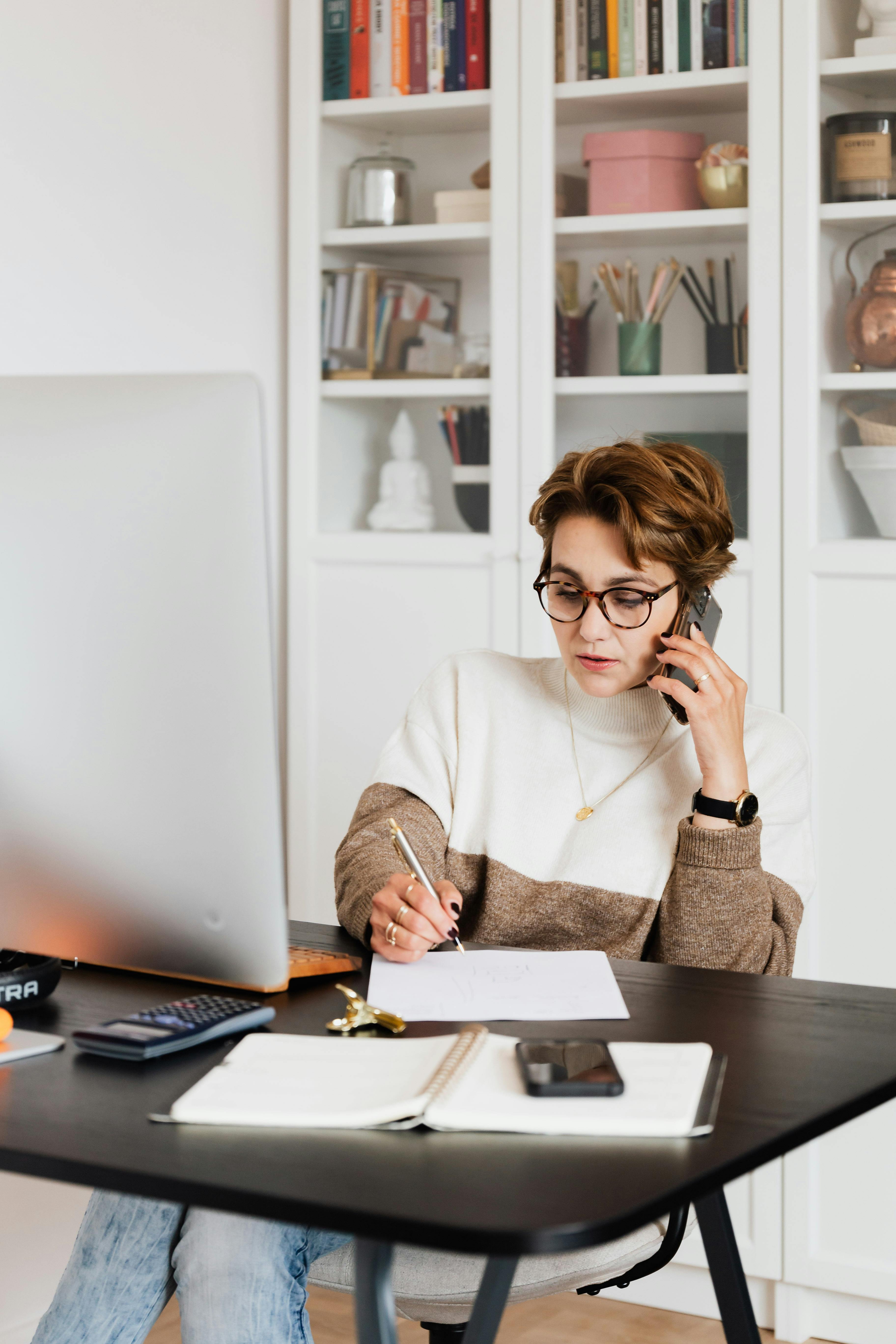 Free Modern businesswoman in casual outfit talking on mobile in office Stock Photo