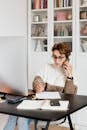 Modern businesswoman in casual outfit talking on mobile in office