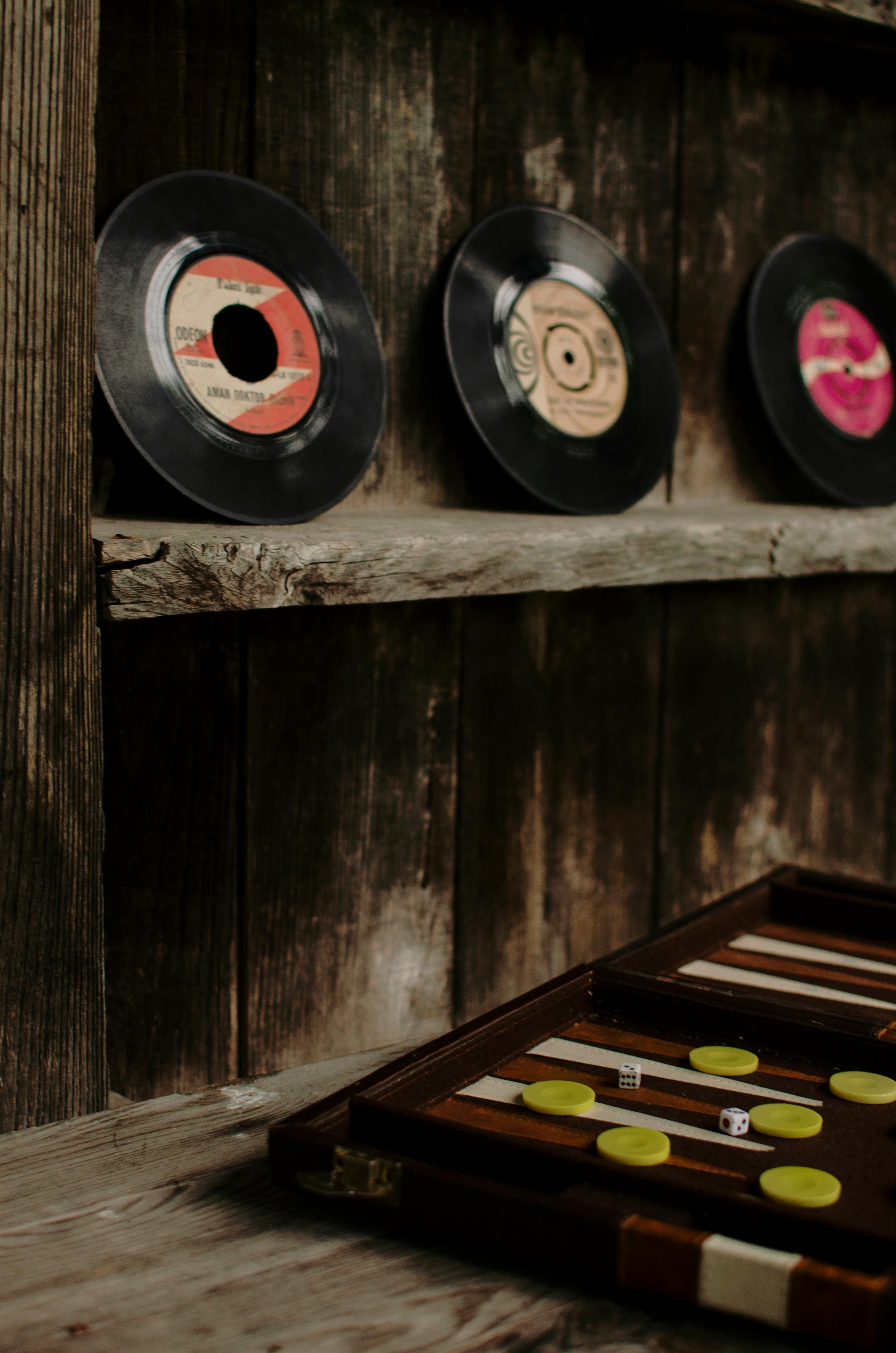 old vinyl records on weathered shelf with backgammon