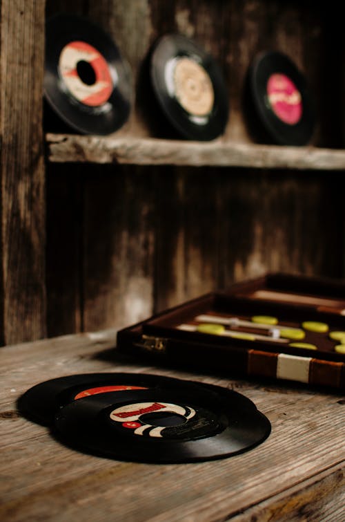 Free Collection of various classic vinyl records placed on old wooden table near backgammon game in vintage store Stock Photo
