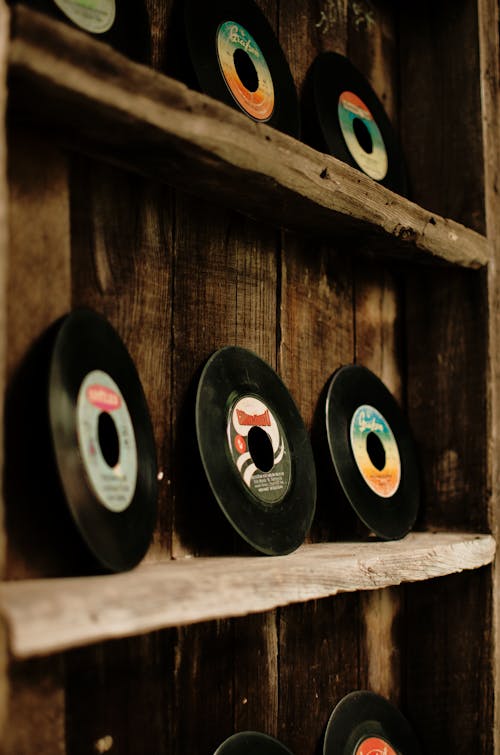 Various retro vinyl records arranged on wooden stand in workshop