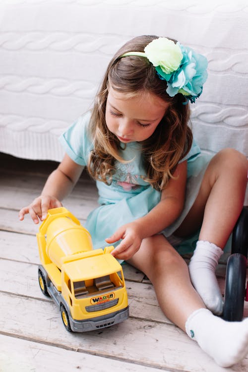 A Young Girl Playing with Her Toy Car