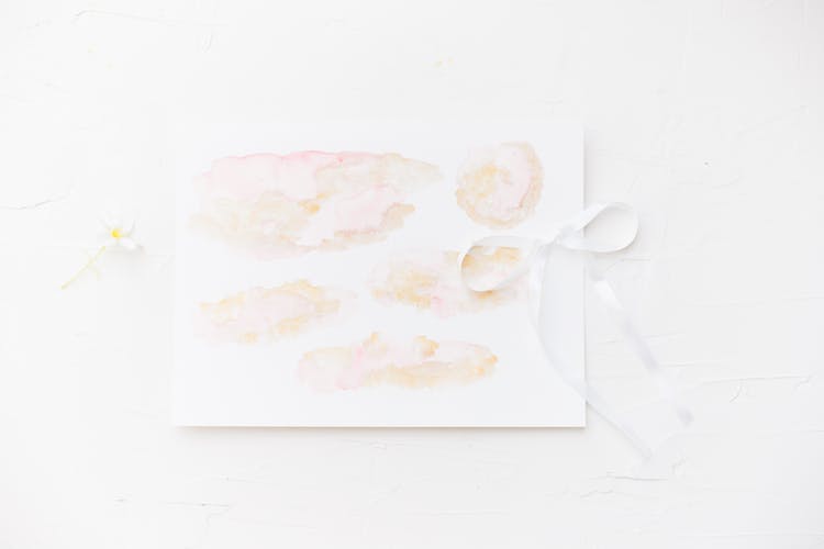 White Card With Painting And Ribbon On White Background