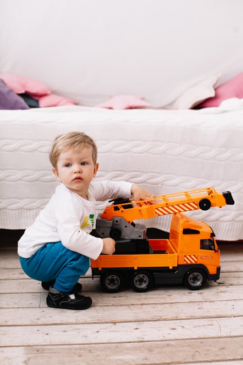 A Young Boy Playing Holding a Toy Car