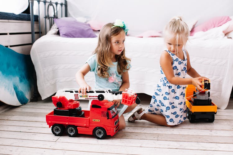 Young Girls Playing With Toy Cars