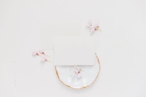 White Paper and Flowers on White Ceramic Plate