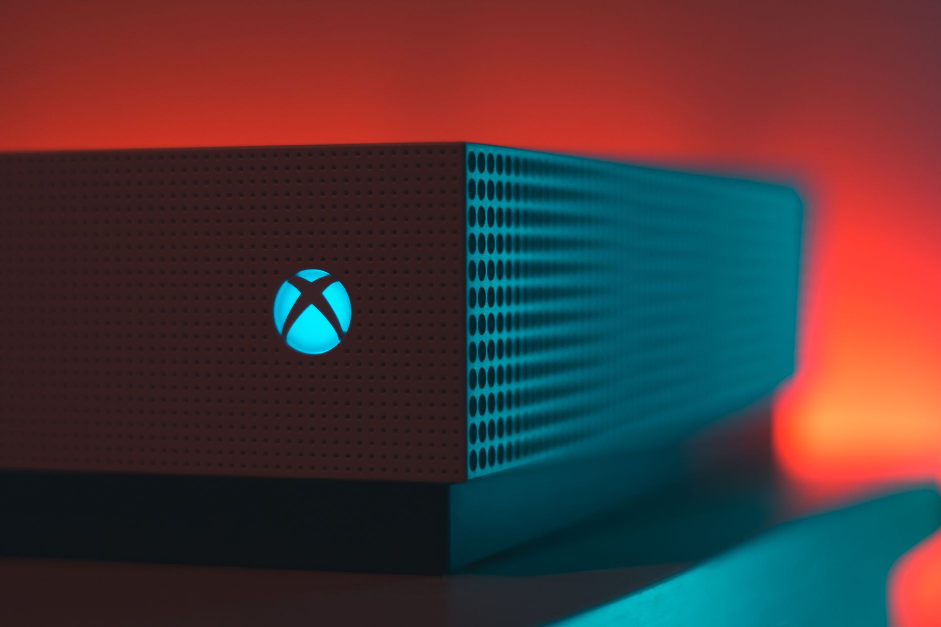 Close-up of an illuminated gaming console with a red and blue light aura.