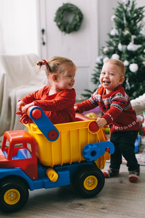 Free Two Babies Playing with Plastic Toy Truck Stock Photo