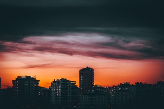 在现代城市地区，当代建筑上空，风景如画的五颜六色多云日落天空
