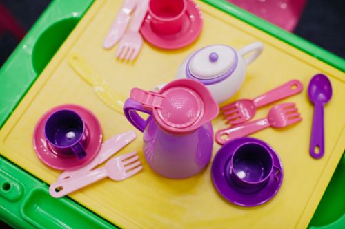Free Bright plastic tea set with cups and utensils on a vibrant table top view. Stock Photo