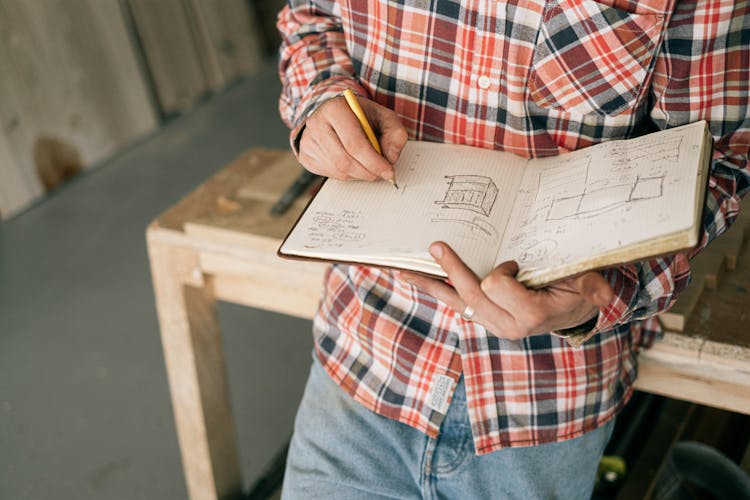 Crop Carpenter Drawing Furniture Sketches In Notebook