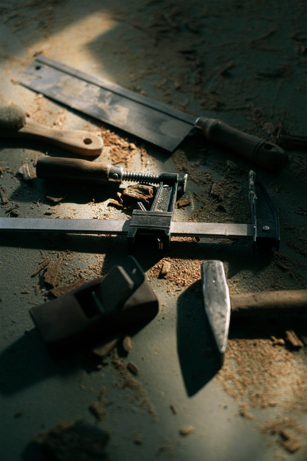 Vintage woodworking tools on a workbench under dim workshop light
