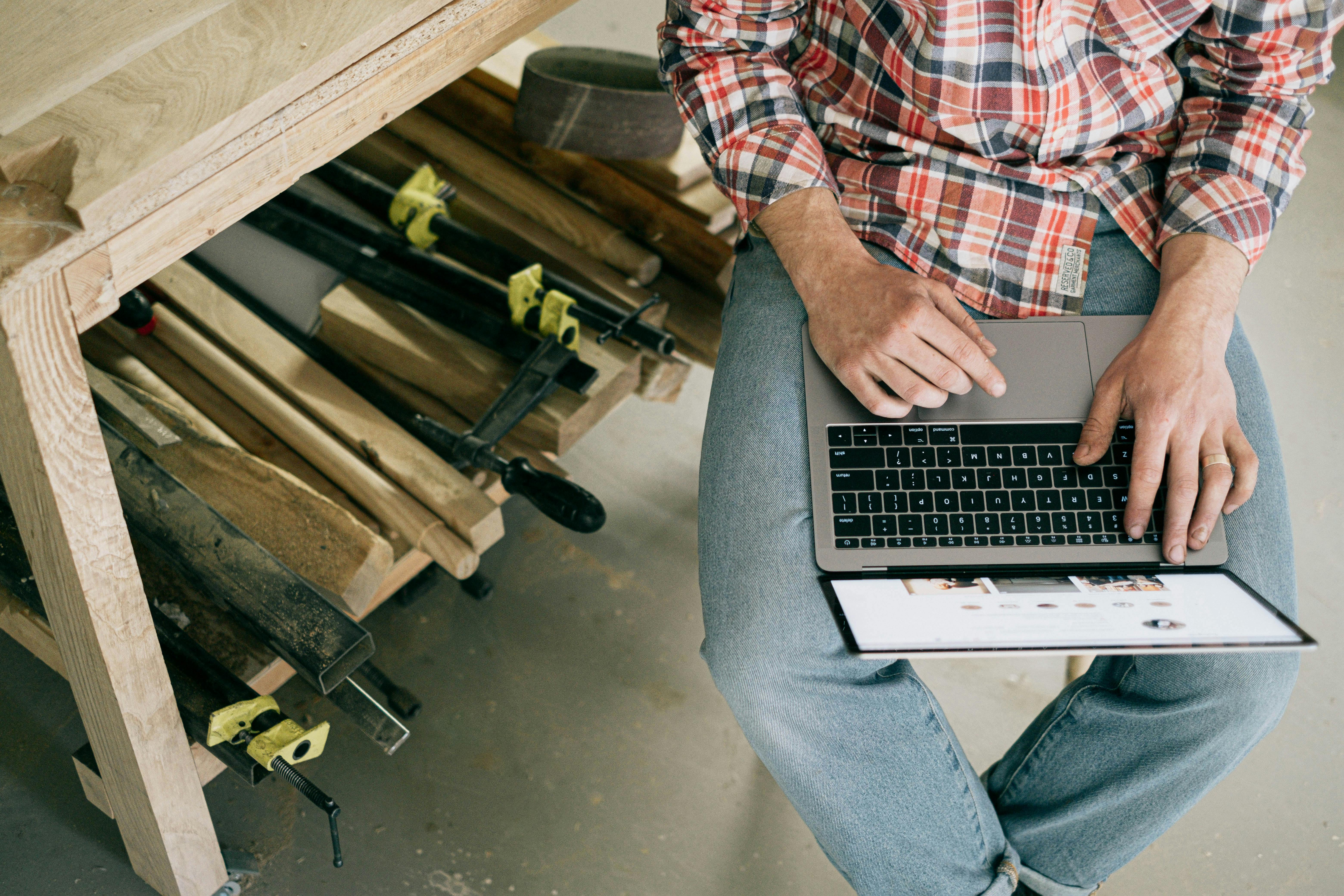 person in blue denim jeans sitting on chair using macbook pro