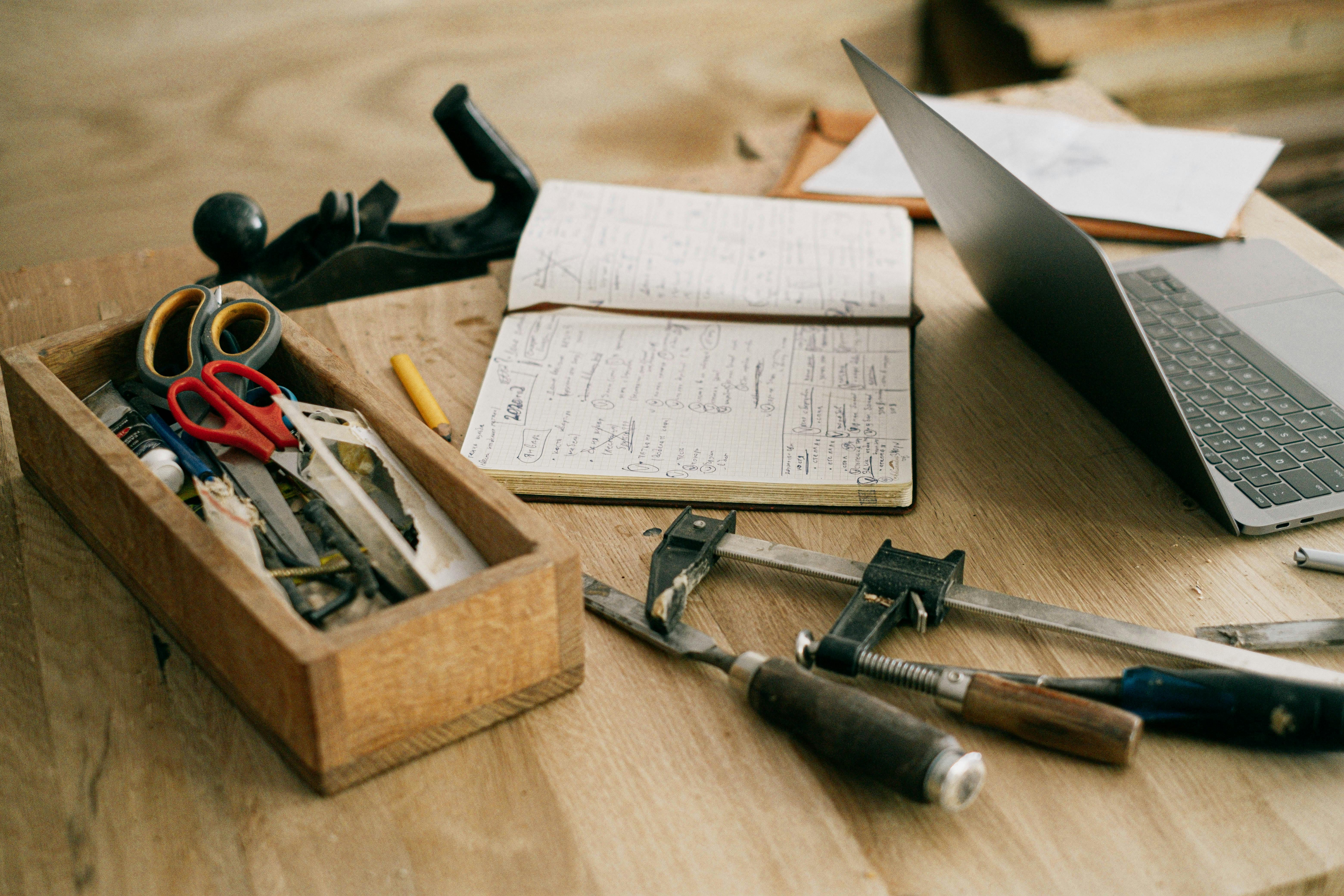 black and silver hand tool on brown wooden table