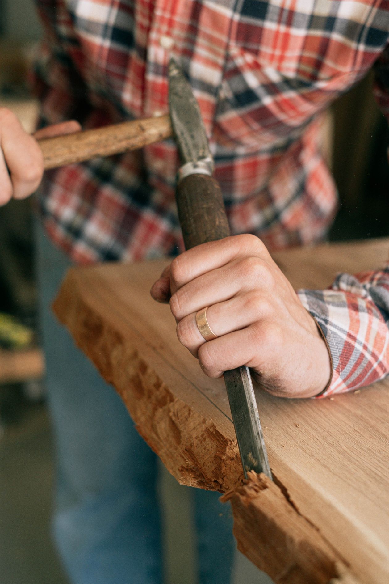 Close-up of a craftsman carving wood with a chisel