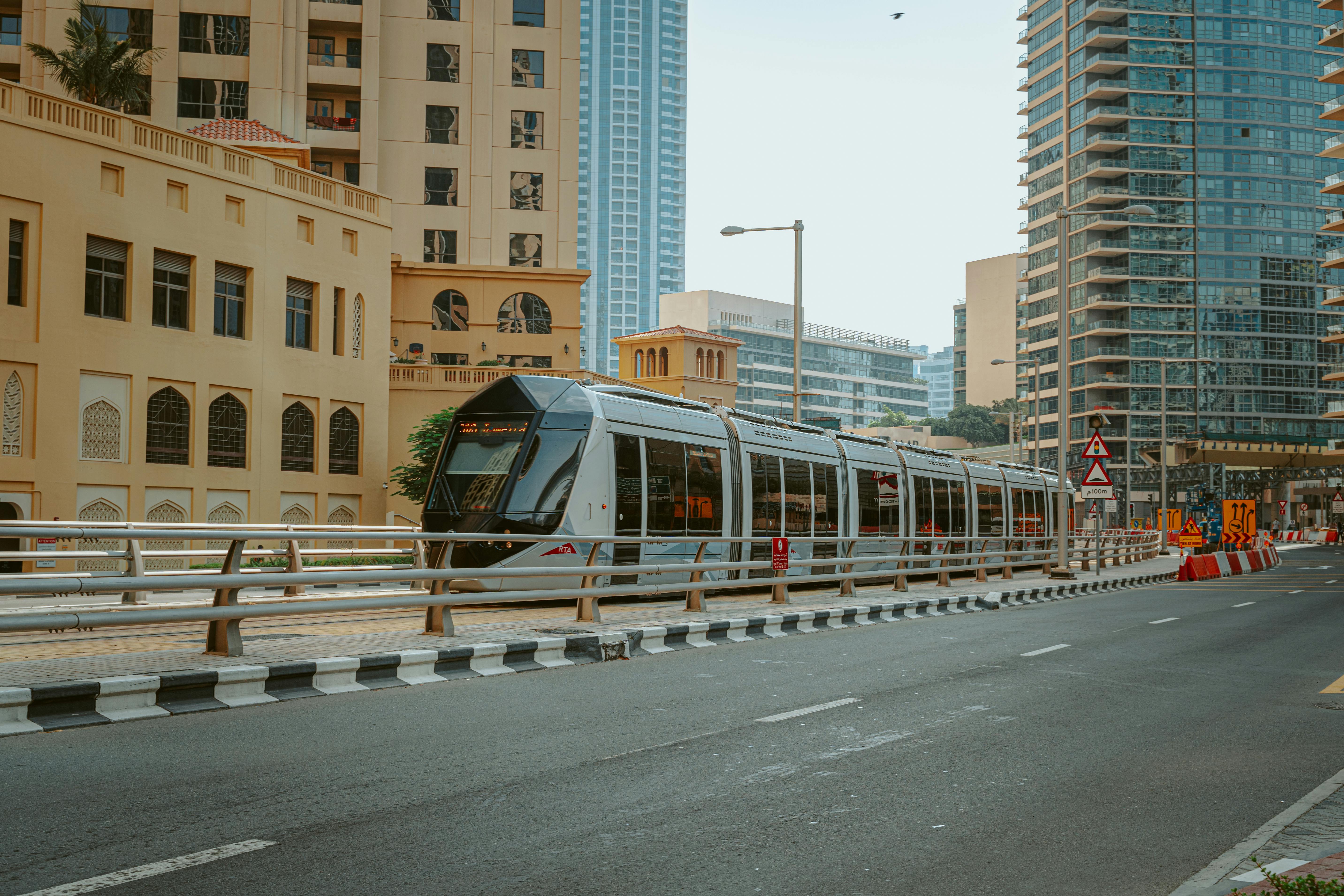 View of a sleek tram passing through downtown Dubai, showcasing the blend of traditional and modern architecture.