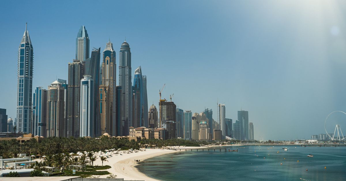 A person holds a smartphone displaying a digital UAE visa application against a blurred office background.